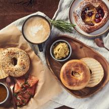a table with a plate of food with bagels and dips