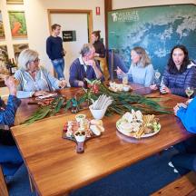 a group of people sitting around a table with food