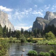 a river with mountains in the background with people in it