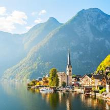 a town next to a body of water with mountains