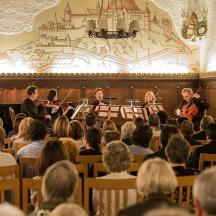 en gruppe mennesker sidder i et rum med musik