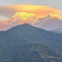 a view of a mountain with the sun shining on it