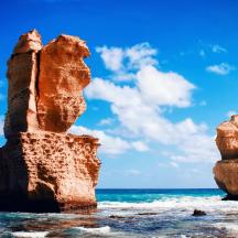 two stacks of rocks in the water on the beach