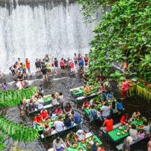 a group of people standing in front of a waterfall