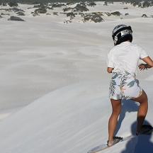 una persona in piedi su una tavola da surf nella sabbia