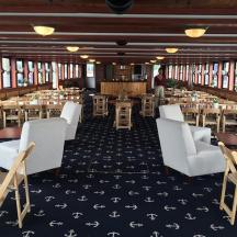 a restaurant with tables and chairs in a room with windows