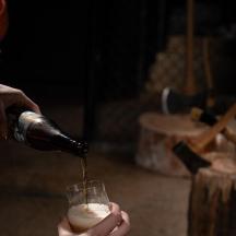 en person, der hælder en drink i et vinglas
