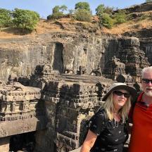 a man and a woman standing in front of a temple