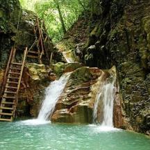 una cascada al mig d'una muntanya amb una escala