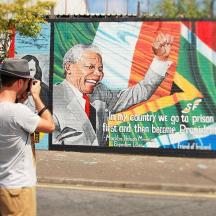 a man talking on a cell phone in front of a billboard