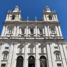a large building with a tower with statues on it