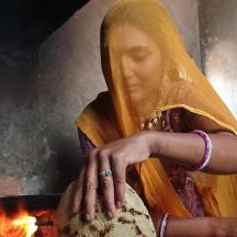 a woman wearing a yellow veil sitting next to a fire