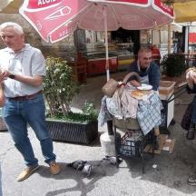 a group of people eating food on the street