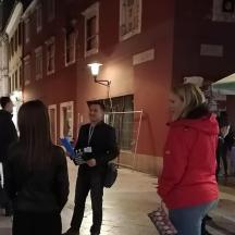 a group of people walking down a street at night