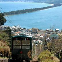 a green tram on a hill near the water