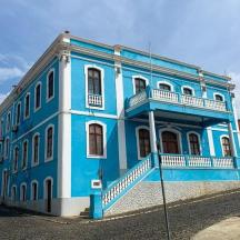 a blue building with white trim on a street