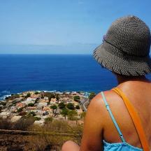 a person wearing a hat looking out at a city