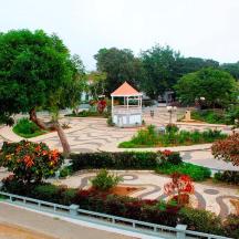 a park with a gazebo and flowers and trees