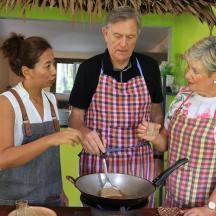 a man and two women in a kitchen preparing food