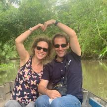 a man and woman sitting in a boat on a river