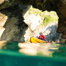 a man in a yellow kayak in a cave