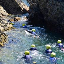 a group of people in a river with helmets on
