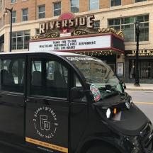 ein schwarzes Auto, das vor einem Theater geparkt ist