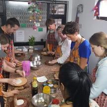 a group of people standing around a counter preparing food