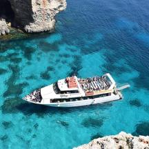 a boat in the water next to some rocks