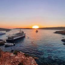 a group of boats in the water at sunset