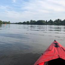 a red kayak in the water on a river