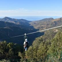a person on a zip line in the mountains
