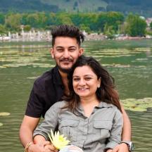 a man and a woman standing in front of a lake
