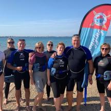 un groupe de personnes posant pour une photo sur la plage