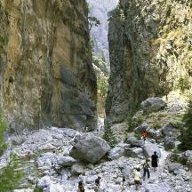a group of people walking through a rocky canyon