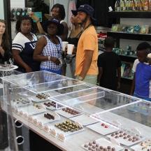 a group of people standing around a display of chocolate eggs