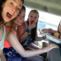 a group of girls sitting in the back of a car