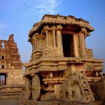 a large stone building with a wheel in front of it