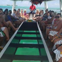 a group of people sitting on a boat on the beach