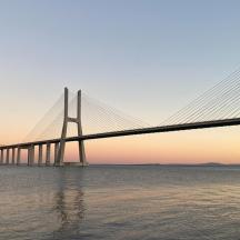 eine Brücke über ein Gewässer bei Sonnenuntergang