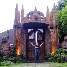 a woman standing in front of a building with statues
