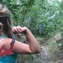 a woman holding a knife in the woods