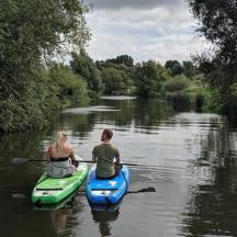 a man and woman in a kayak on a river