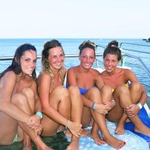 eine Gruppe von Frauen, die auf einem Boot im Wasser sitzen
