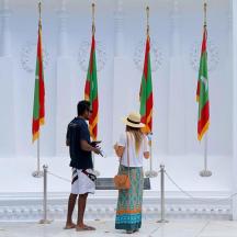 a man and a woman standing in front of flags