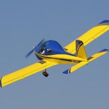 un avió blau i groc volant al cel