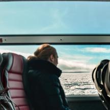 a man sitting on a boat looking out at the water