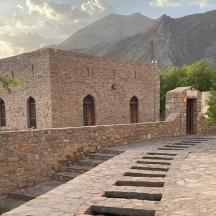 a brick building with a stone wall and stairs