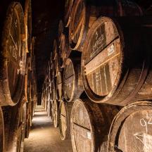 una fila de barriles de vino de madera en una bodega
