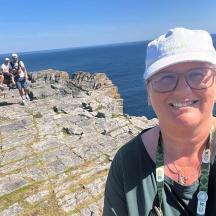 a woman standing on the edge of a mountain